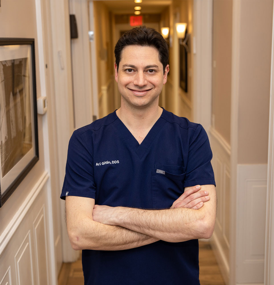 headshot of doctor standing in the halls of the dental center