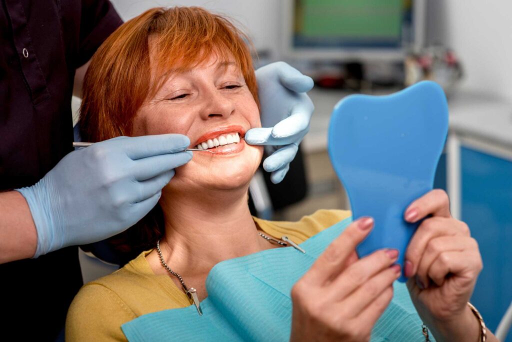 Implant Patient Looking in the Handheld Mirror