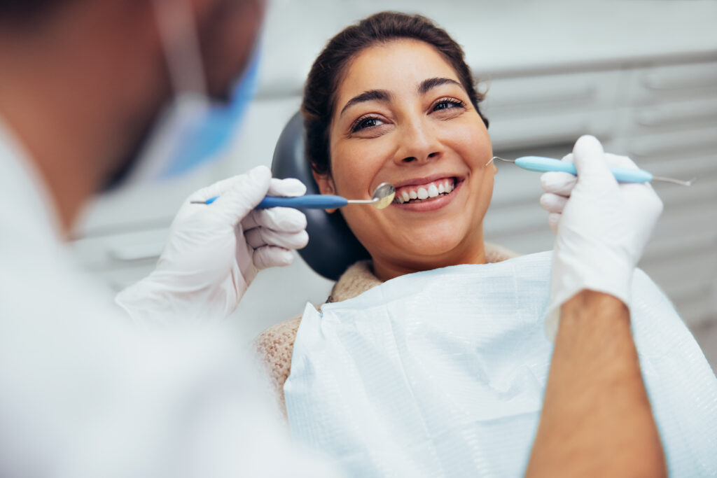 Smiling patient having her teeth examined by a dentist at Gitlin Dental Group